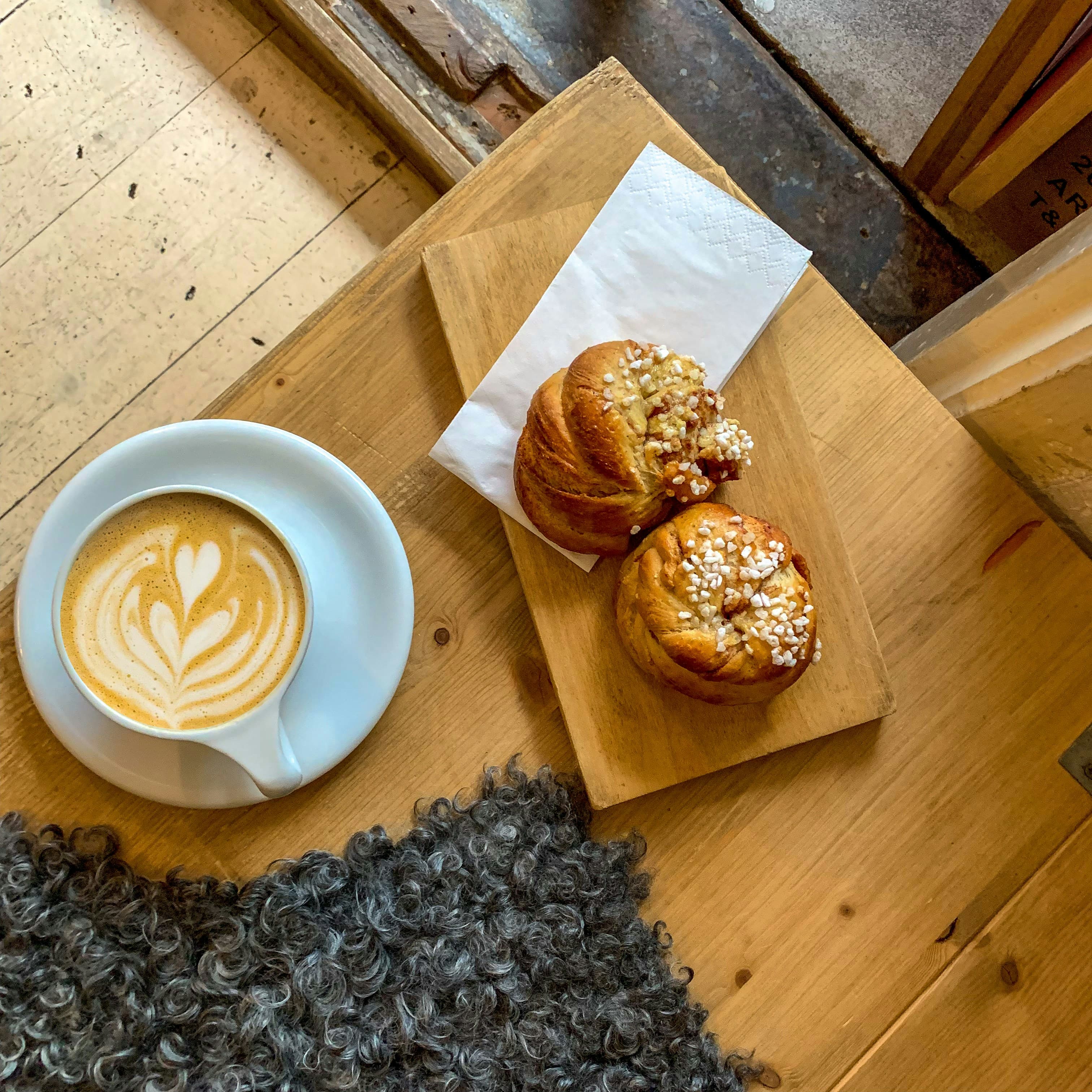 Two cardamom buns on a wooden board