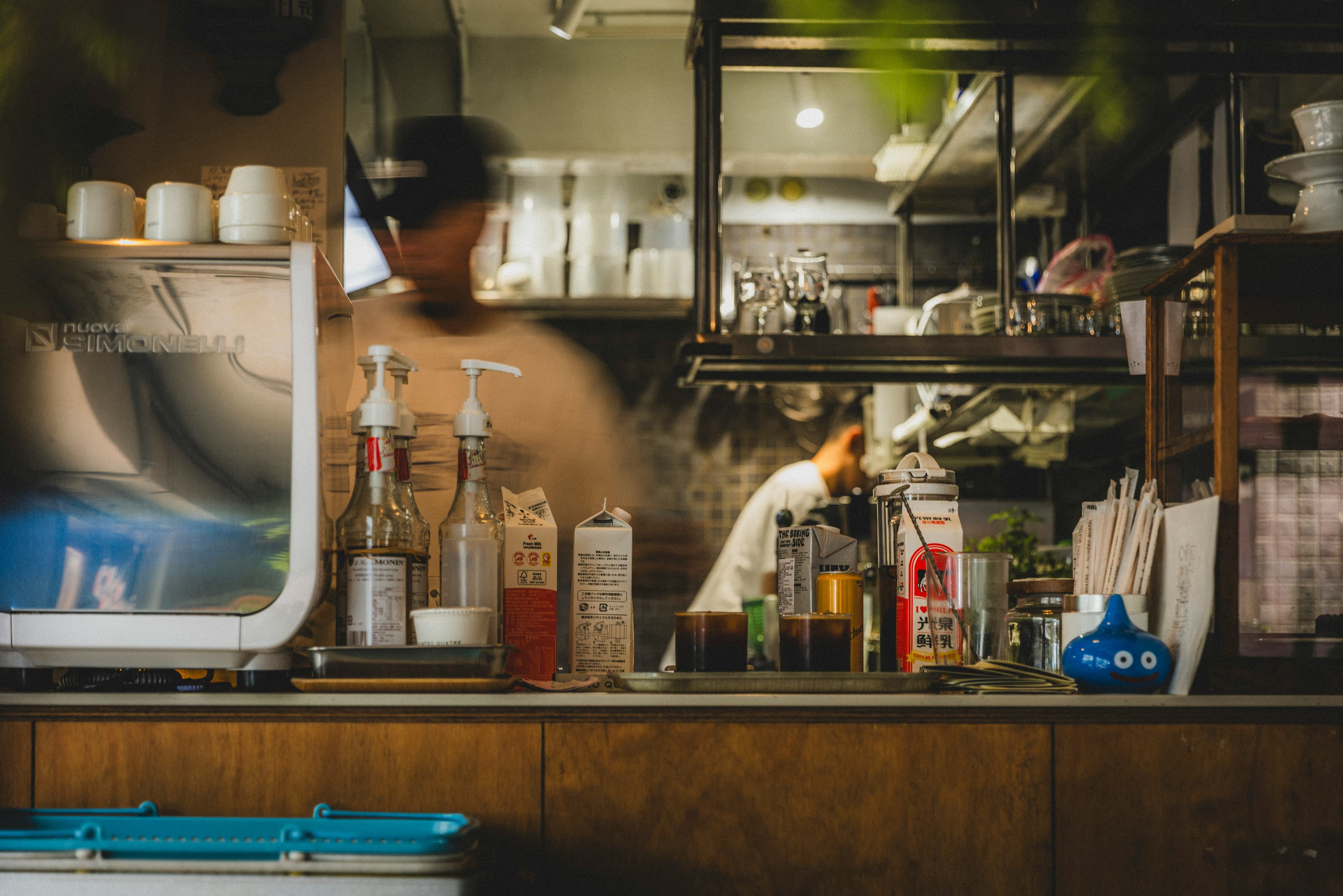 Espresso bar with milk cartons, syrups and cups lined up on the counter