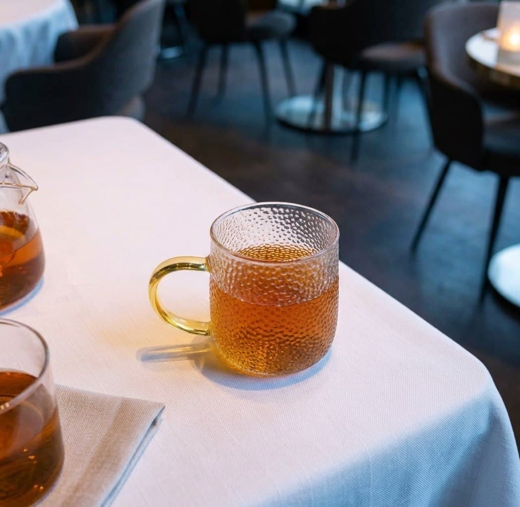 Hot jasmine tea in a textured glass mug