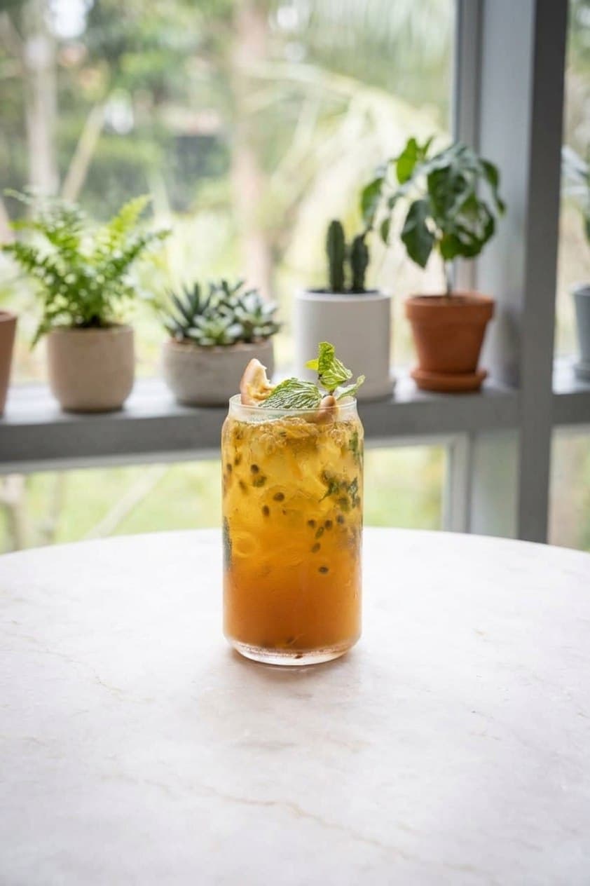 Passion fruit iced tea with mint in a tall glass